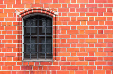 Red brick wall with the iron window gratingの写真素材