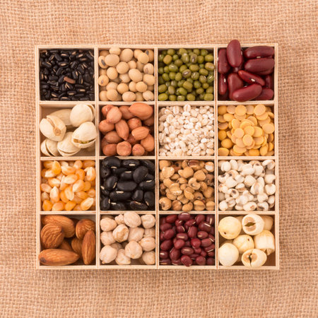 Assortment of beans and lentils in wooden spoon with wood box macadamia isolated on white . mung bean, groundnut, soybean, red kidney bean , black bean ,red bean and brown pinto beans .の写真素材