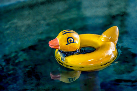 A yellow duck floats serenely in a quiet pool, reflecting both nostalgia and simplicity. This...