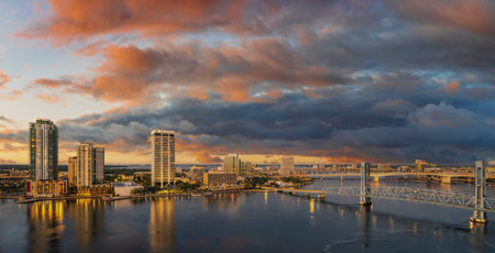 Warm storm-charged clouds sweep over the city as its towers rise against a sky alive with shifting color and dramatic weather.の写真素材