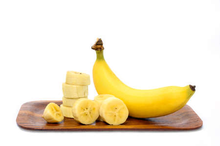 Ripe banana and slices of banana on wooden tray isolate on white backgroundの写真素材