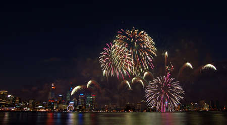fireworks over the city with reflection in riverの写真素材