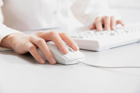 Secretarys hand touching computer keys during work の写真素材