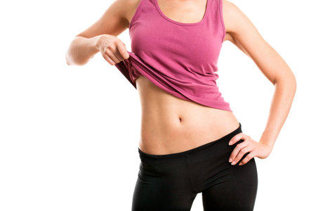Happy fitness woman shows her belly