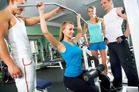 Fitness. Woman at the gym doing arms exercises on a machine