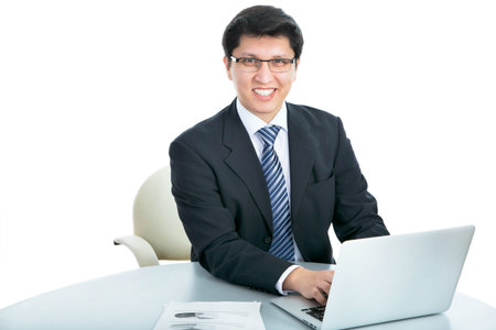 Happy business man sitting in front of laptop on a white background