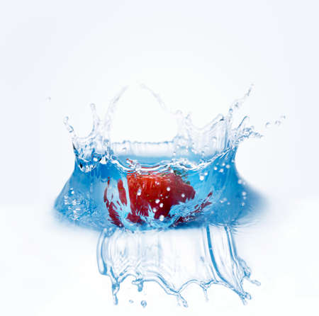 Strawberry falls deeply under water with a splashの写真素材