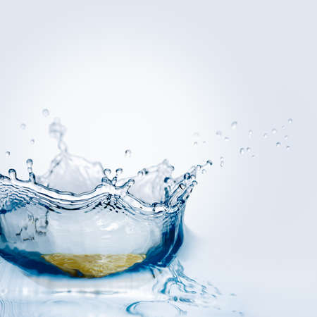 Beautiful splash of water falling from a slice of lemonの写真素材