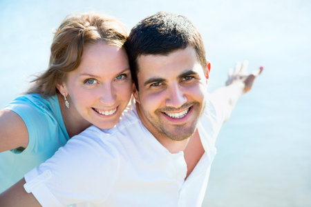 Portrait of love couple embracing outdoor in park looking happy