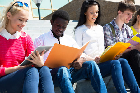 Group of university students studying reviewing homework