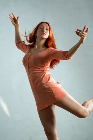 Beautiful young woman dancing in the old hallの写真素材