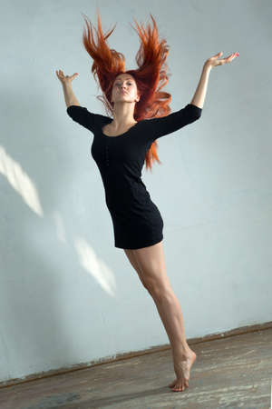 Beautiful young woman dancing in the old hallの写真素材