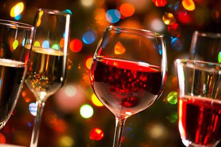 Crystal glasses of wine on the background of Christmas lightsの写真素材
