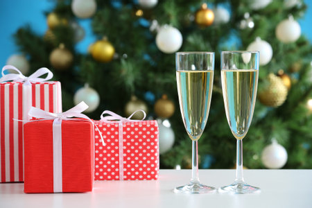 Glasses of champagne and Christmas gifts on the backgroundの写真素材