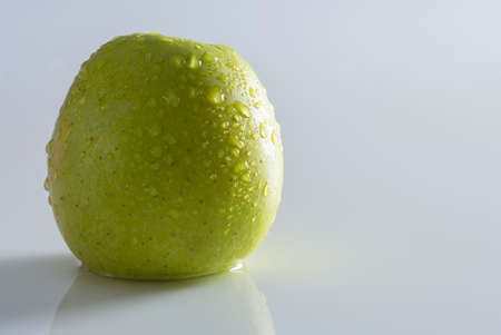 Green apple in drops of waterの写真素材