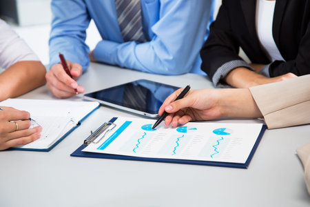 Businesspeople analyzing financial data in office
