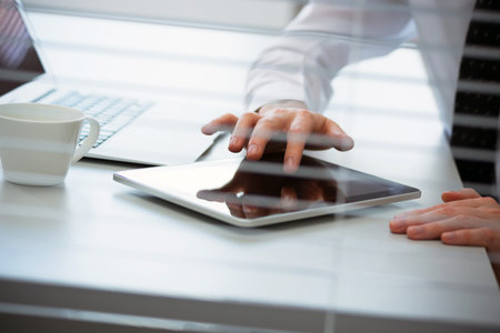 Close-up of hands of business man working on a tablet computer.