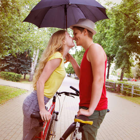 Happy couple kissing in a park in a rainの写真素材