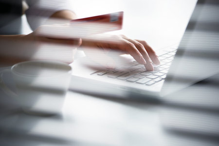 Business woman holding credit card and using laptop. Online pay.