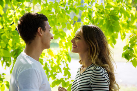 Portrait of a happy couple hugging in a park in sunny day