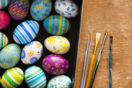 Easter eggs and brushes on wooden backgroundの写真素材