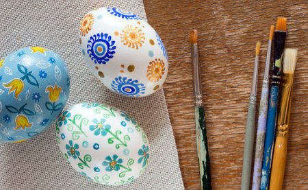 Easter eggs and brushes on wooden background