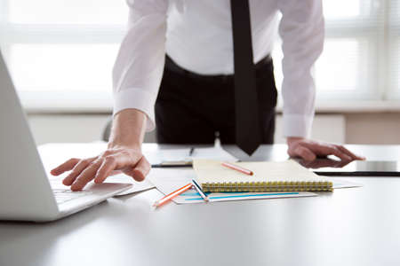 Serious businessman working with laptop in an officeの写真素材