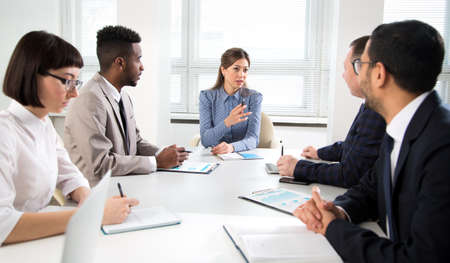 Businesswoman explains to colleagues a new project in the modern office