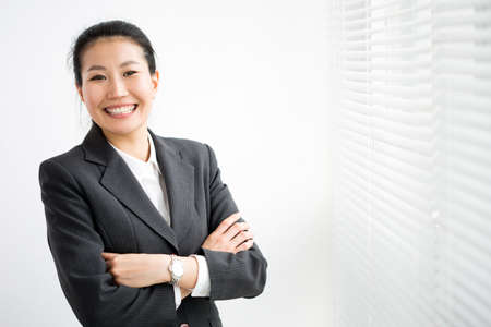 Portrait of successful asian business woman against a window.の写真素材