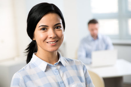 Portrait of young businesswoman and his colleague on the background at the office