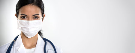 Coronavirus. ?lose-up face of serious hispanic female doctor ?n a gray background for your text.