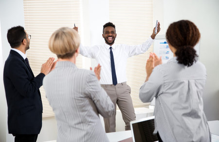 Cheerful business people clapping hands at business seminar.