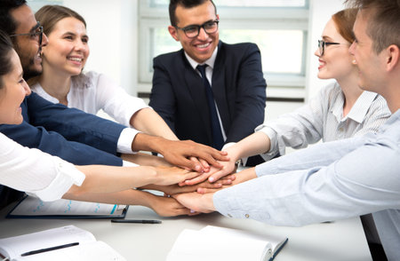 International business team showing unity with their hands together
