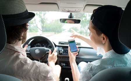 Young happy couple of tourists travel by car using the navigatorの写真素材