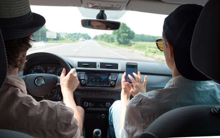 Young happy couple of tourists travel by car using the navigatorの写真素材