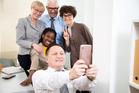 Multy-ethnic group of business people take a selfie at the office together
