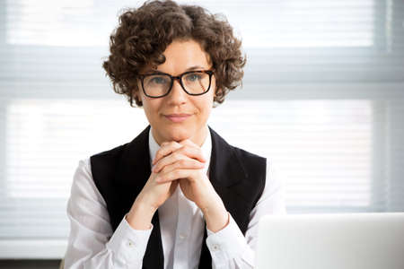 Close-up portrait of a pretty business woman at workplace in officeの写真素材