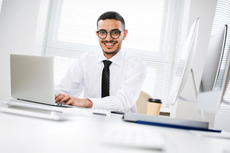 Happy handsome arab businessman smiling while looking at camera in office