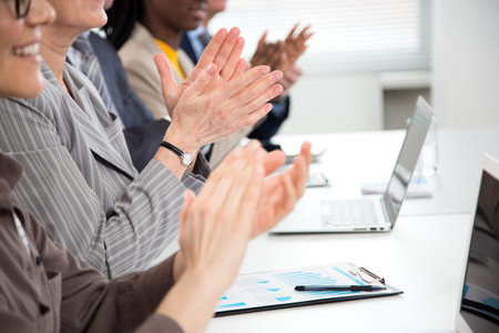 Close-up of business people clapping hands at business seminar.