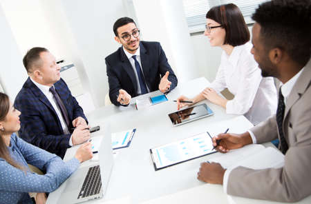 Multy-ethnic group of business people working at the office deskの写真素材