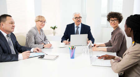 International group of business people working and communicating sitting near office desk together.の写真素材
