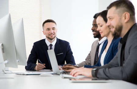 Multy-ethnic group of business people sitting at the office desk and working togetherの写真素材