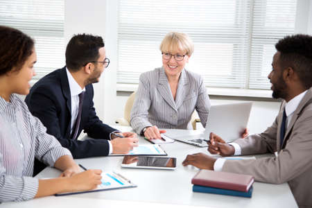 International group of business people working and communicating sitting near office desk together.の写真素材