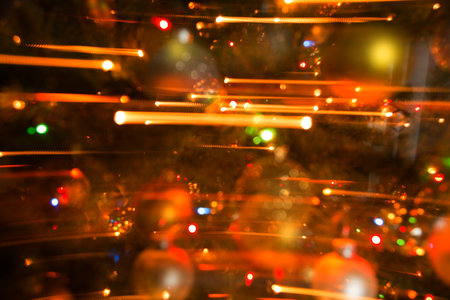 Abstract background of bright colored dynamic lights against the background of christmas decorationsの写真素材