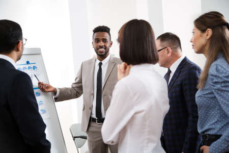 Group of multy-ethnic business people having a meeting using a white board in an office togetherの写真素材