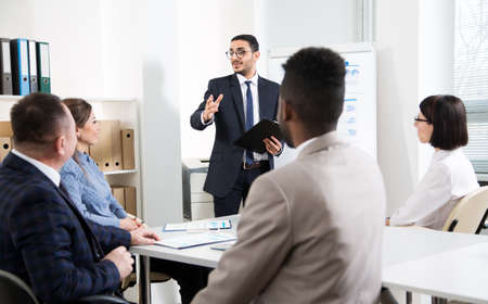 Group of multy-ethnic business people having a meeting using a white board in an office togetherの写真素材