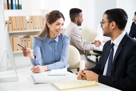 Multy-ethnic group of business people sitting at the office desk and working with computerの写真素材