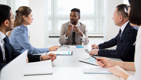 Group of business people sitting around the office desk and discussing the project togetherの写真素材