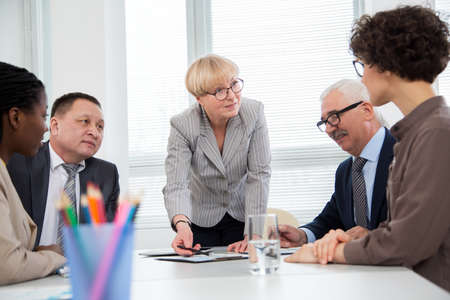 Businesswoman explains to colleague a new project in the modern officeの写真素材