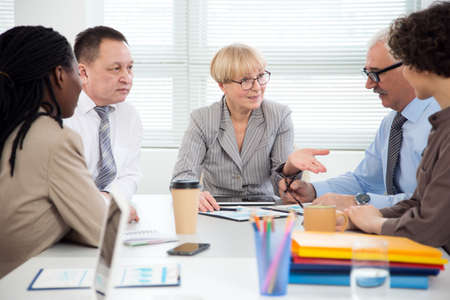 Businesswoman explains to colleague a new project in the modern officeの写真素材